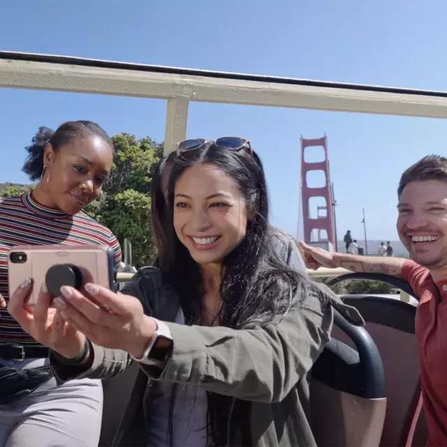 Um grupo de visitantes tira uma selfie em um passeio de ônibus perto da Ponte Golden Gate. São Francisco, Califórnia.